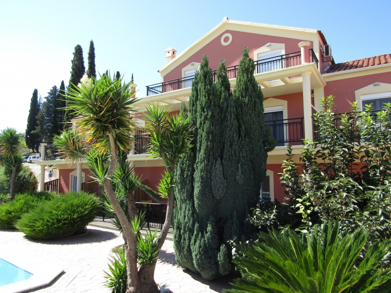 Το κτίριο του Corfu Pearl ανάμεσα σε κυπαρίσσια και φοίνικες